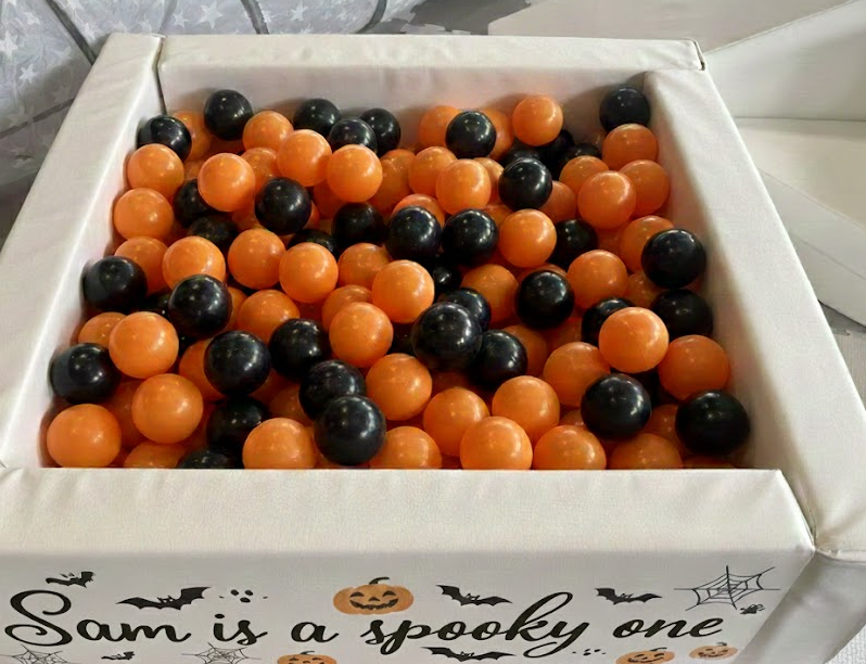 Close-up of ball pit with orange and black Halloween theme balls