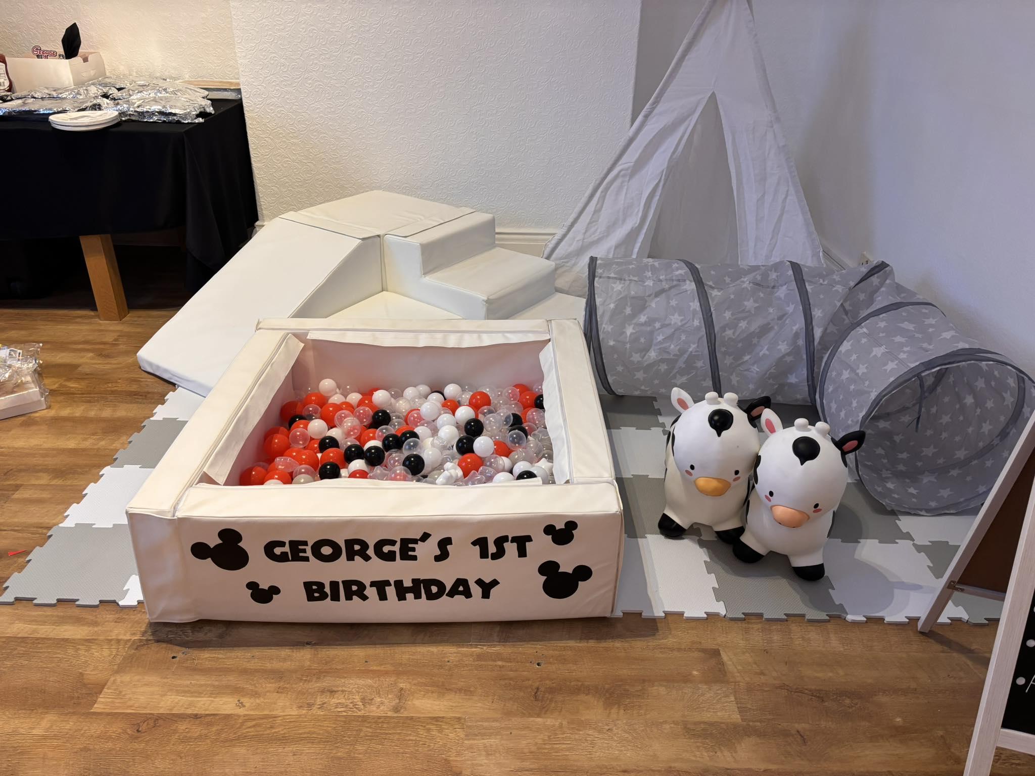 Soft play setup with personalised first birthday signage and themed balls